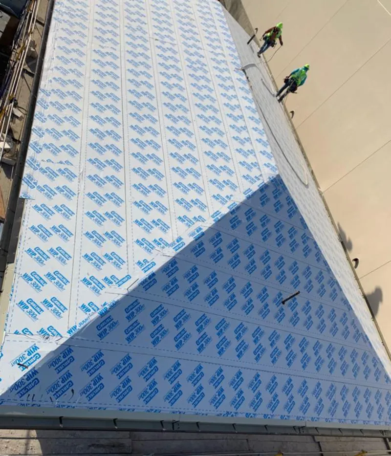 Professional roofers installing underlayment on a metal roof in Chisago City